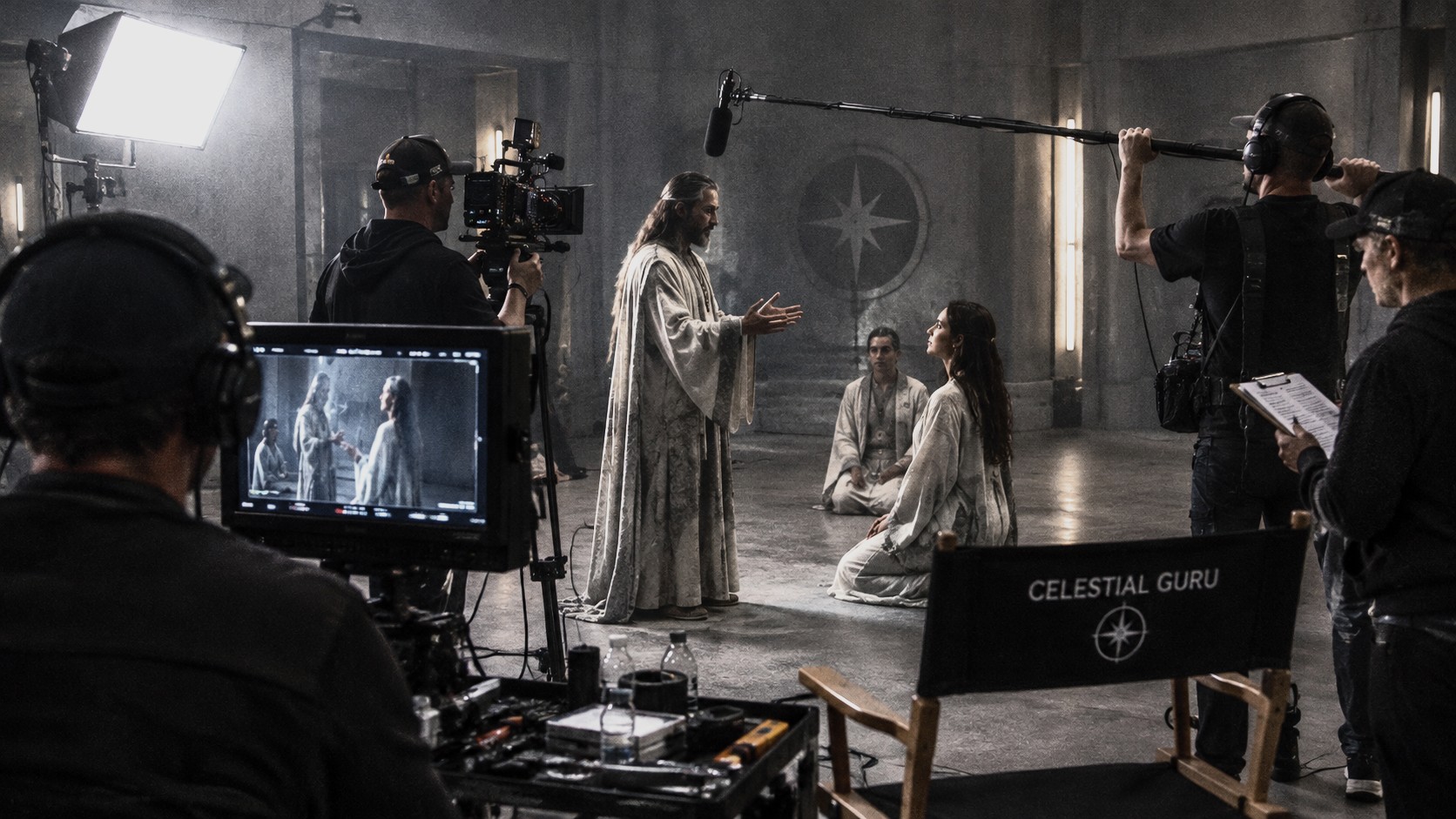 A film set with a camera crew shooting a scene, a director's chair marked Celestial Guru in the foreground